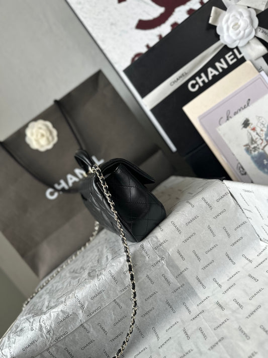 Chanel Mini Flap com alça superior preta, vista de perfil